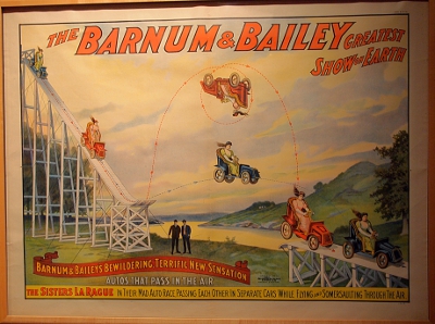 [Barnum & Bailey poster showing cars going down a ramp with one flipping in mid-air over the other.]